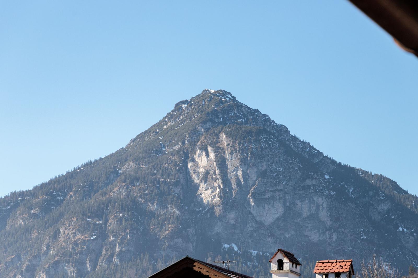 Hochgelegene Berglandschaft mit Schnee und Felsen unter blauem Himmel.
