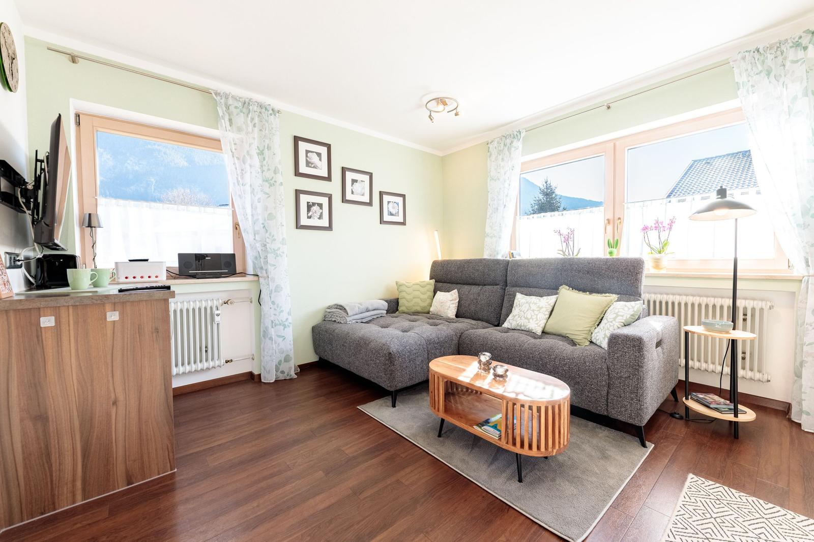 Wohnzimmer mit Sofa, Couchtisch und Fenstern mit Blick.