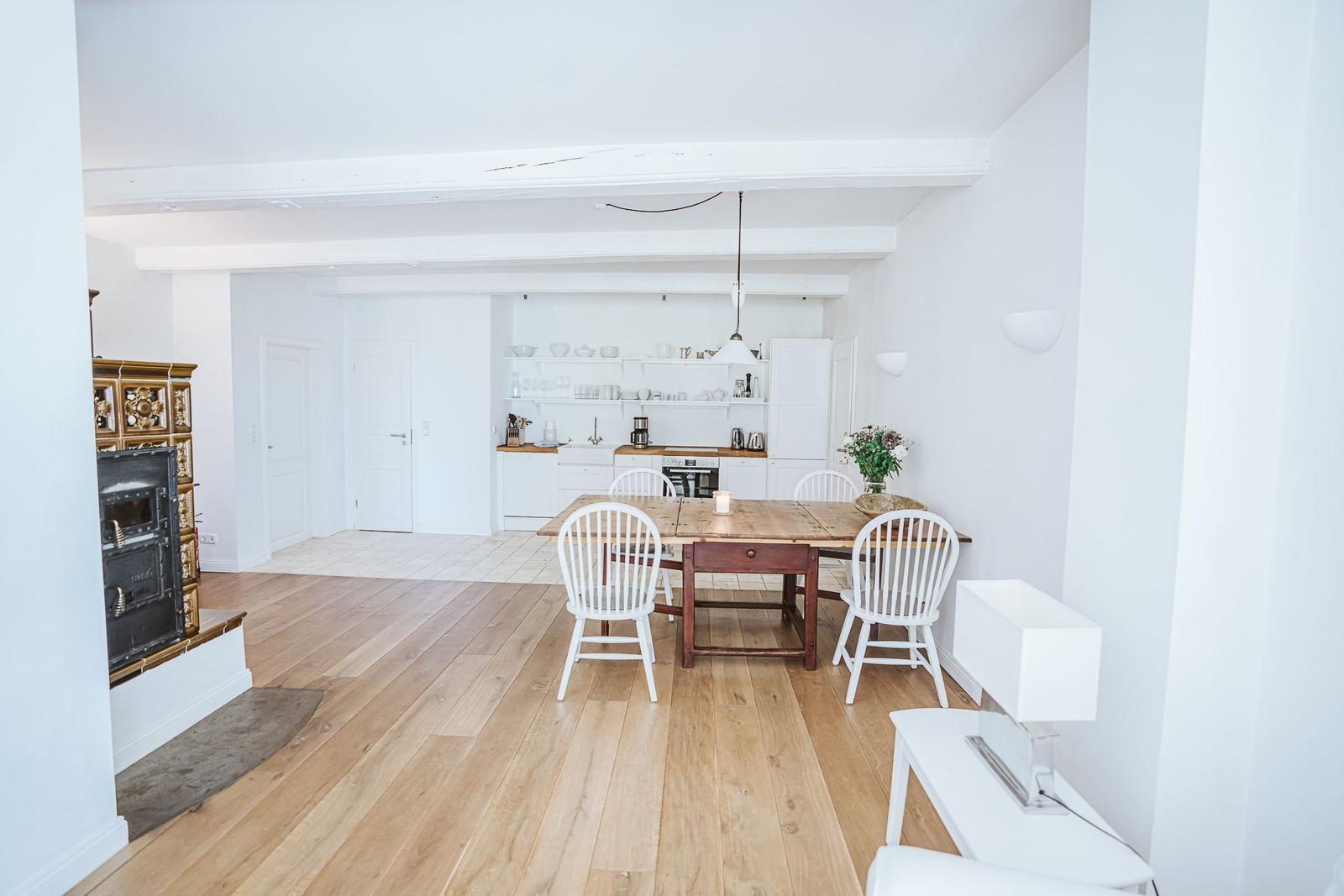 Helle Küche mit Esstisch, Holzboden und Kamin