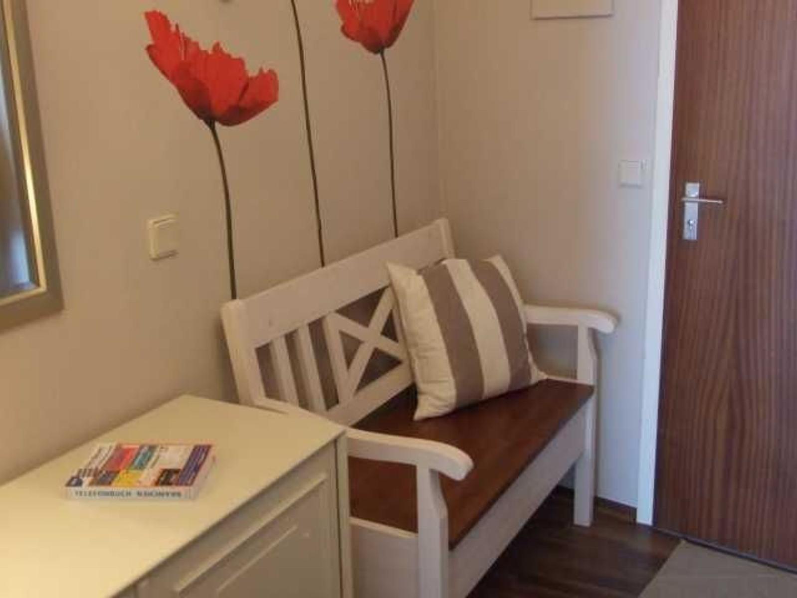 Hocker mit Kissen und Wanddekoration