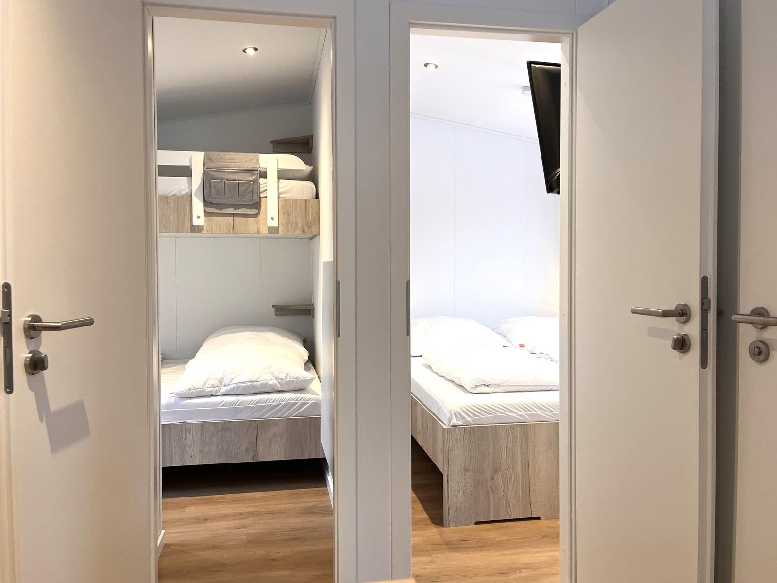 Zwei Schlafzimmer mit jeweils einem Bett und Holzboden