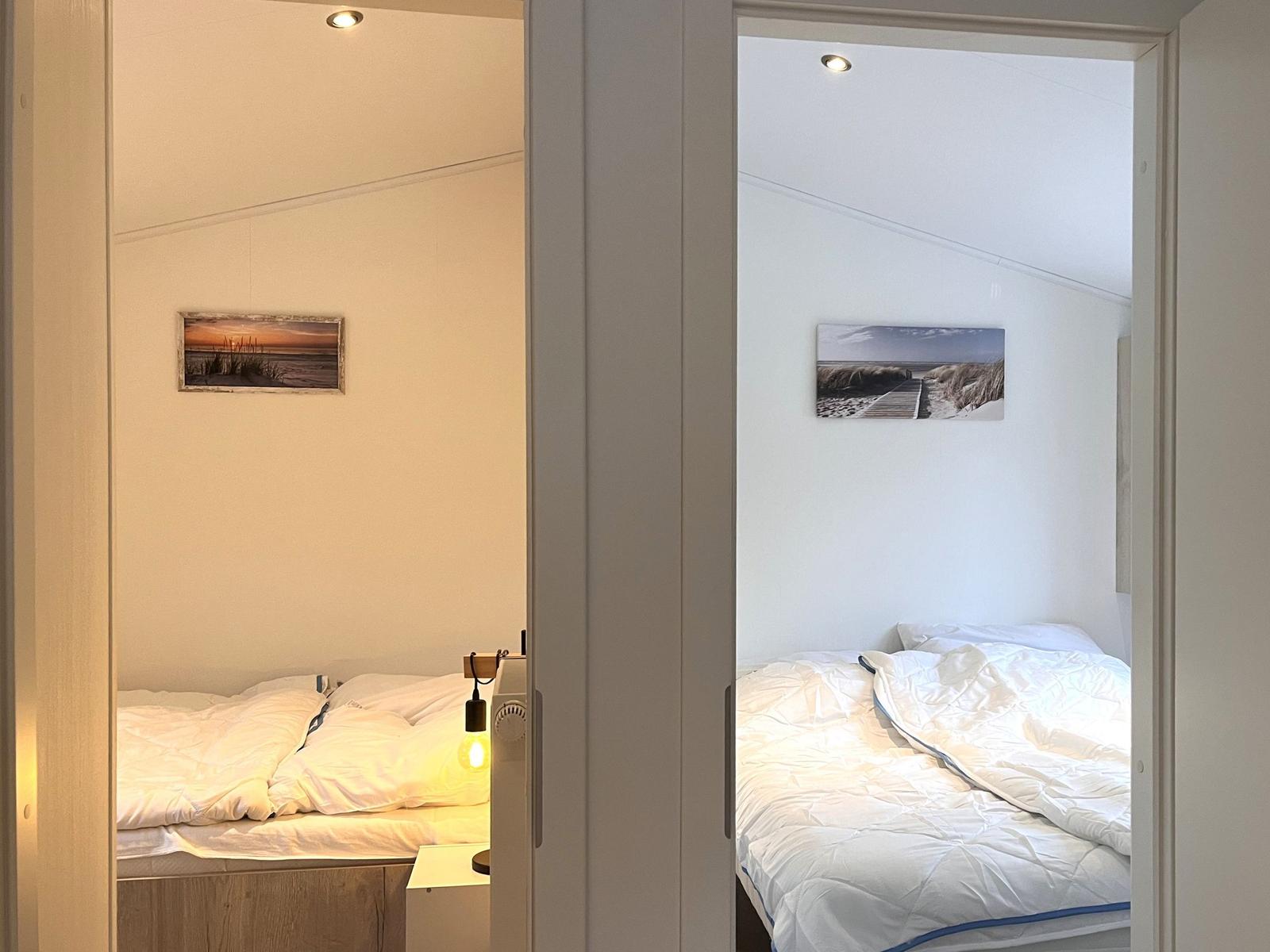 Zwei Schlafzimmer mit Betten und Wandbildern an der Wand.