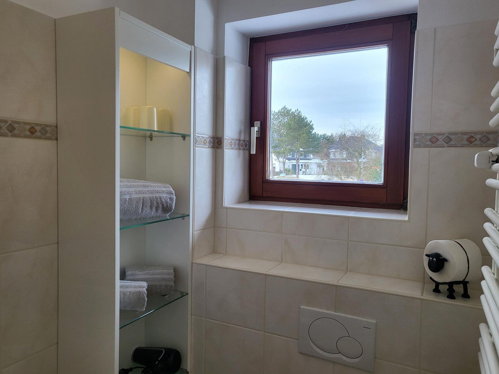 Badezimmer mit Fenster, Regal und Heizung