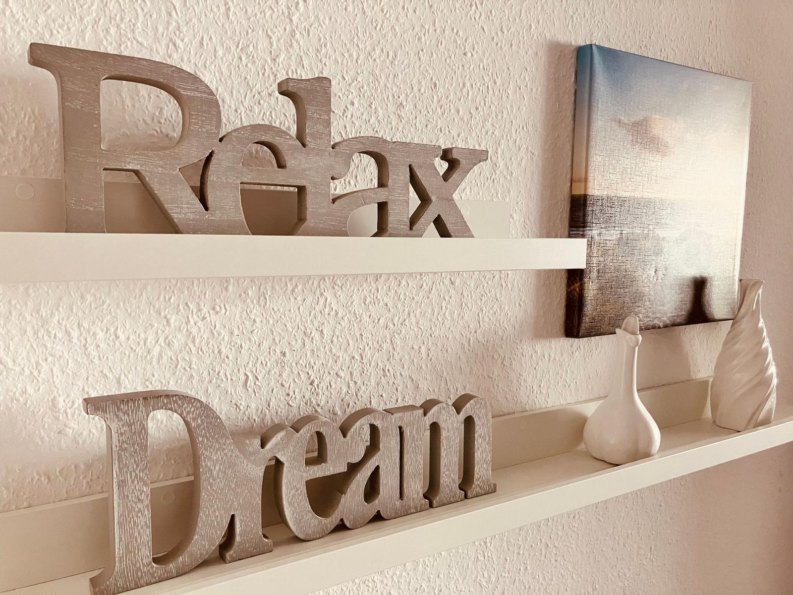 Regal mit Holzlettern Relax und Dream sowie Vasen und Bild.