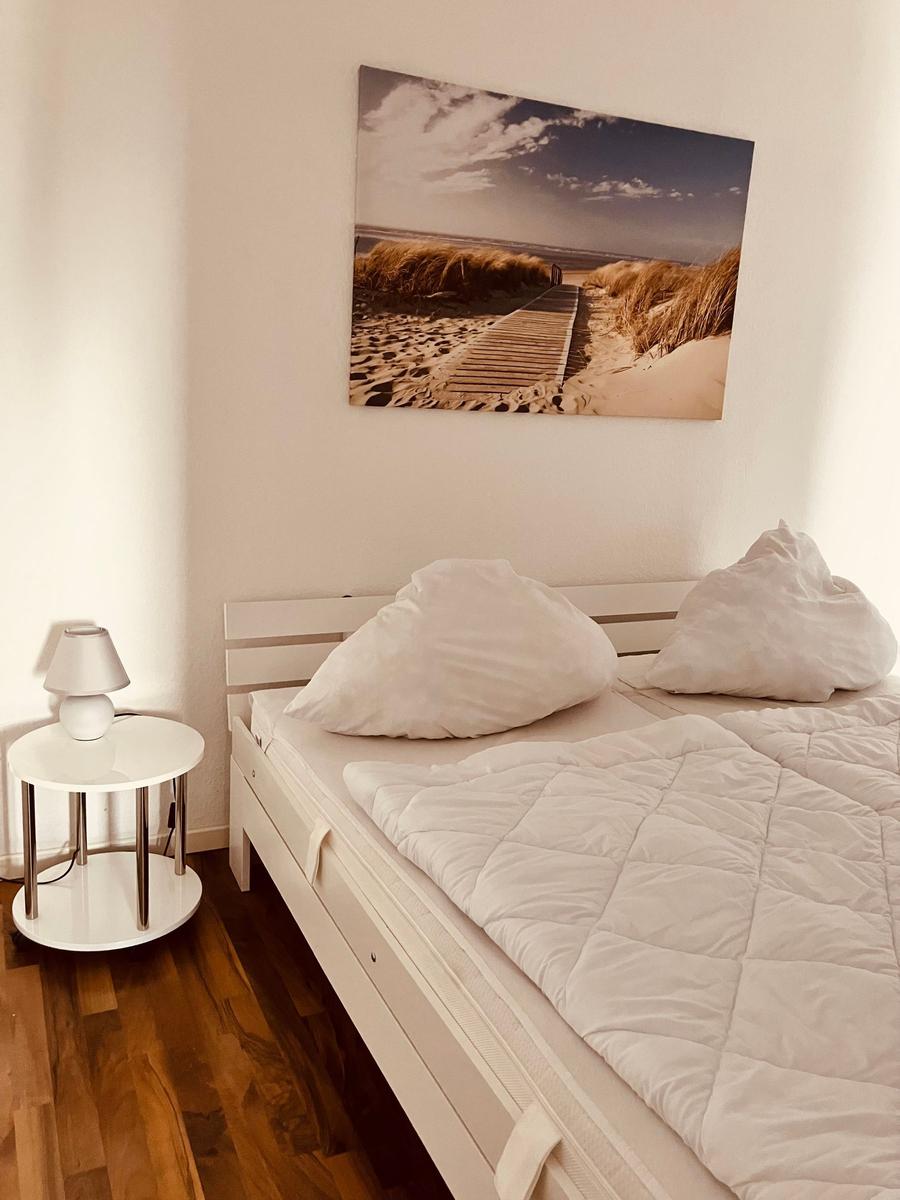 Schlafzimmer mit Bett, Nachttisch und Wandbild
