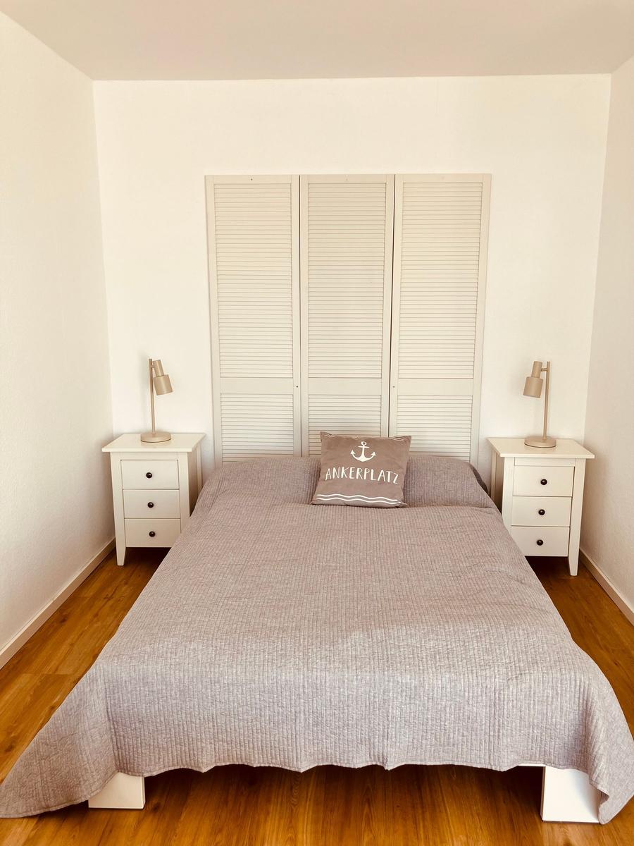 Schlafzimmer mit Bett, zwei Nachttischen und Kleiderschrank.