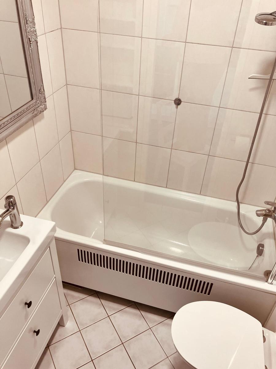 Badezimmer mit Badewanne, Dusche, Waschbecken und Toilette.