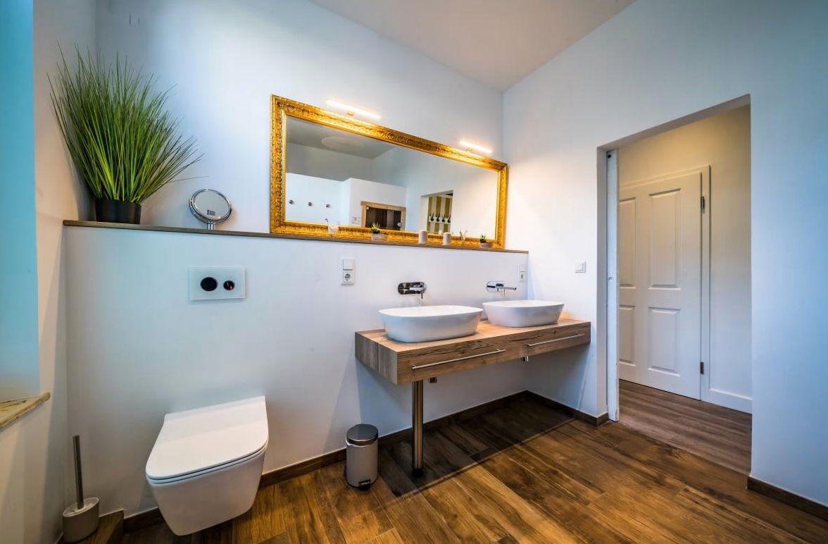 Badezimmer mit Waschtisch, Spiegel und Toilette