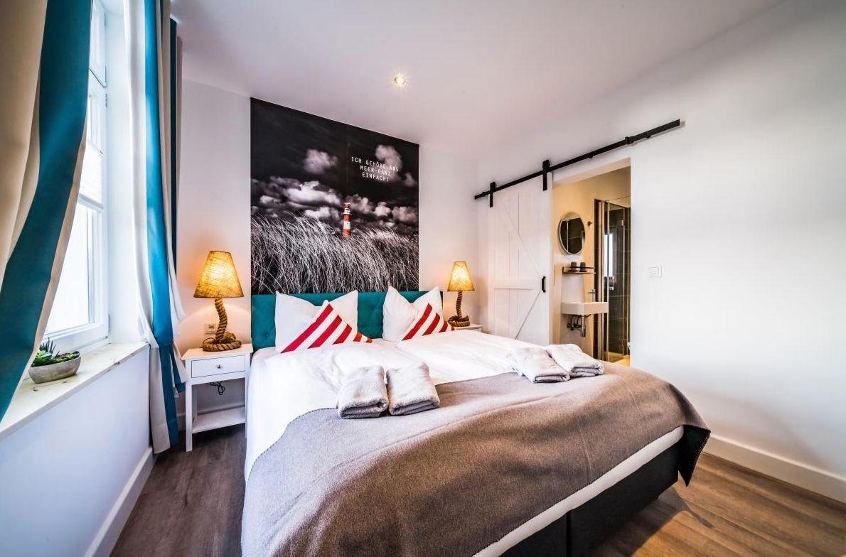 Schlafzimmer mit Bett, Wandbild und Schlafzimmer-Tür.