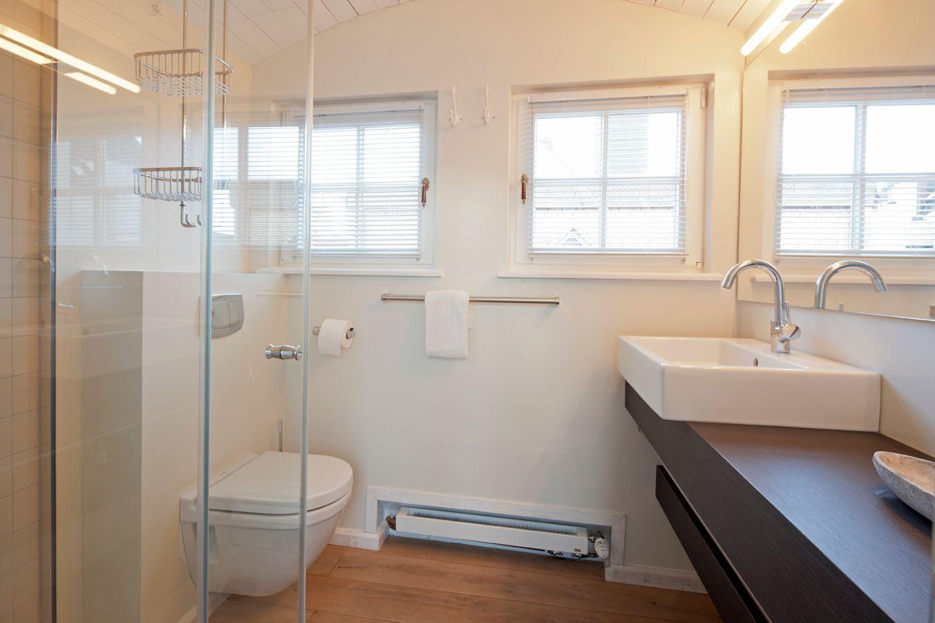 Badezimmer mit Dusche, Toilette und Waschbecken.