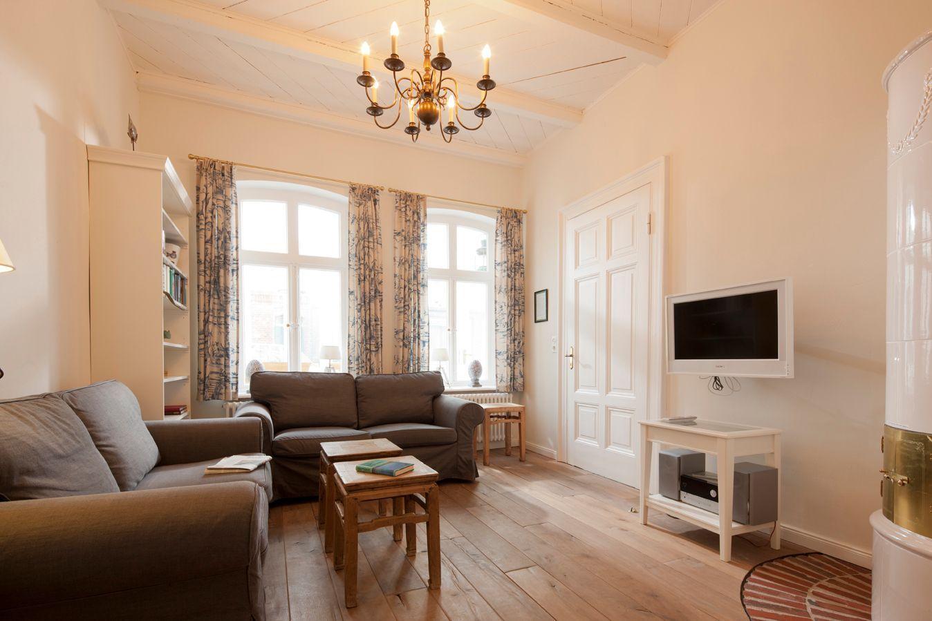 Wohnzimmer mit Sofa, Fernseher und Holzboden.