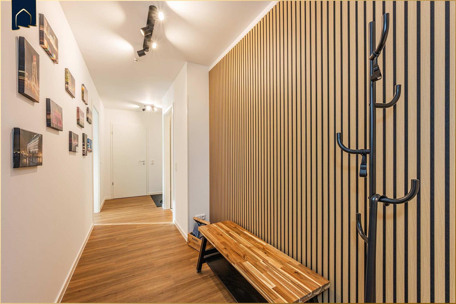 Flur mit Holzwand, Bänkchen und Haken für Jacken.