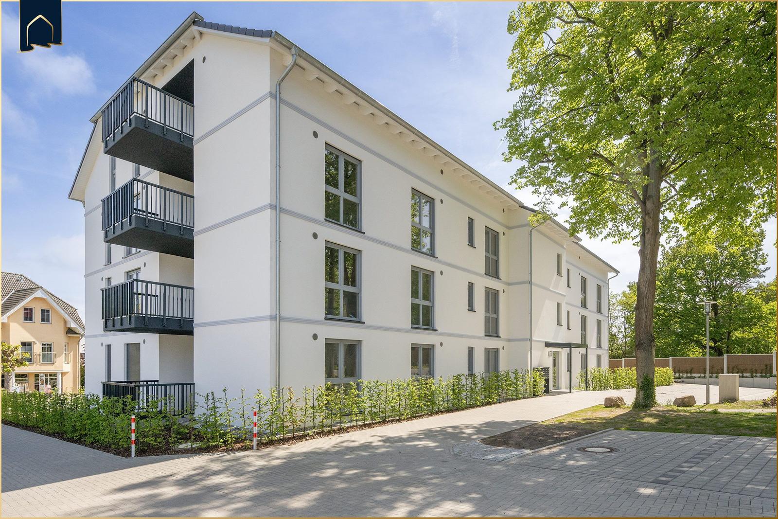 Moderne Wohnanlage mit Balkonen und grüner Umgebung.