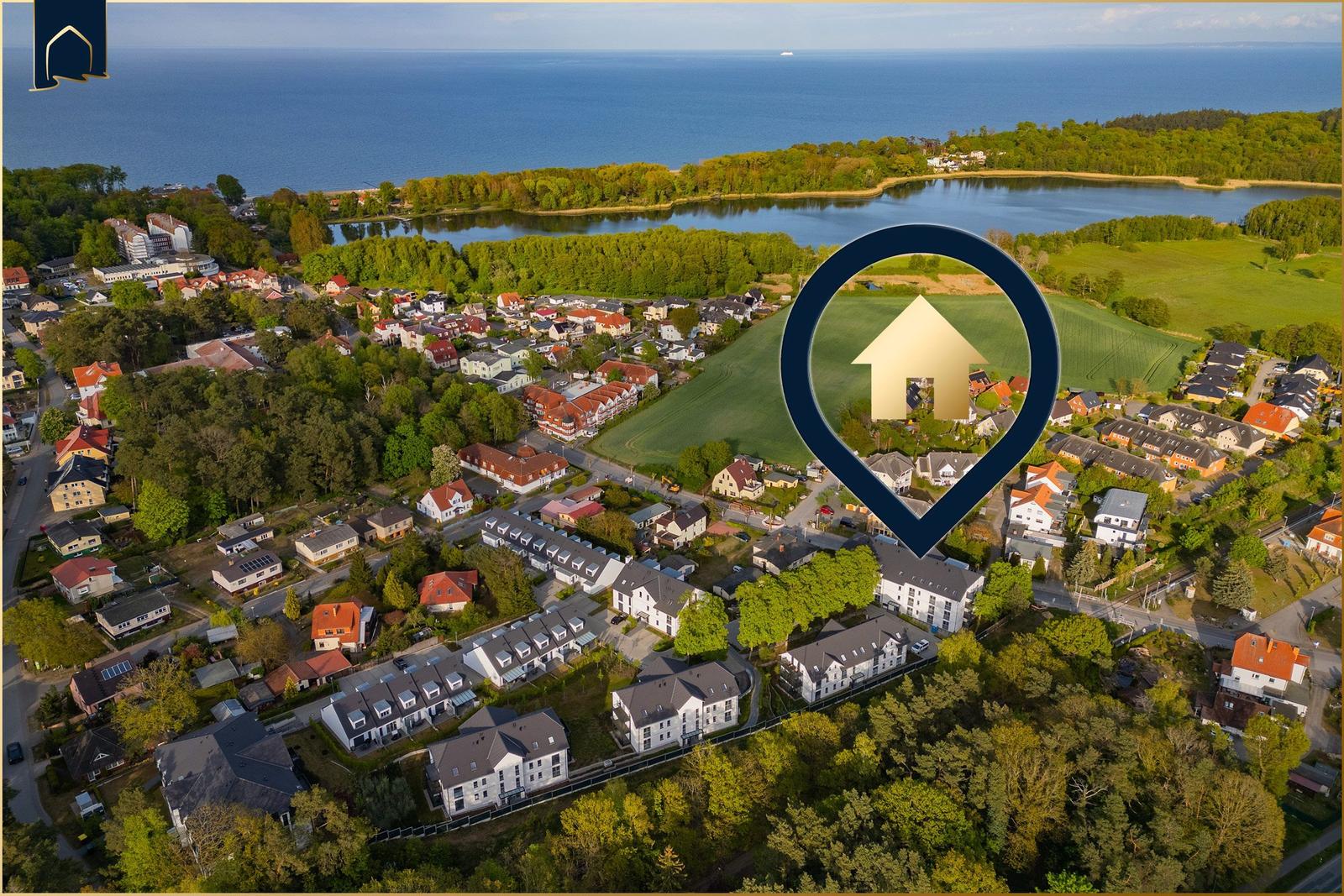 Luftbild von Wohnhäusern an einem See mit Blick auf das Meer.