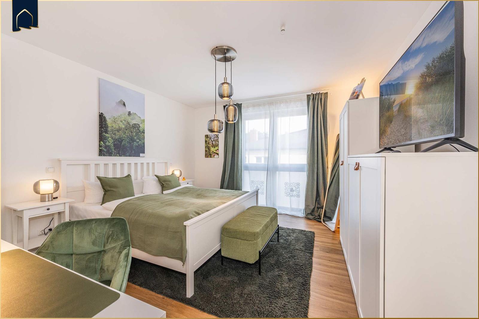 Schlafzimmer mit Bett, TV und Fenster