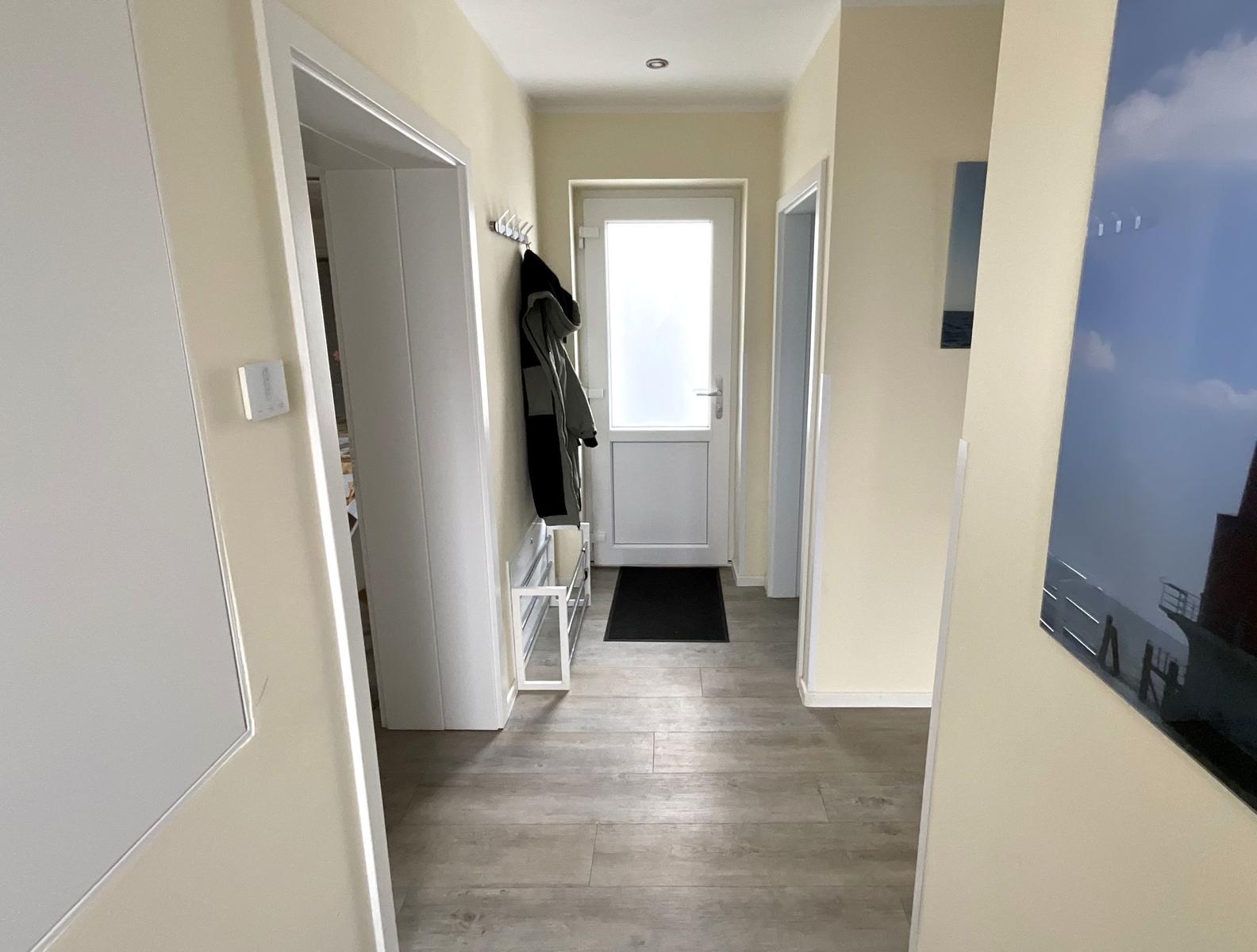 Flur mit Tür, Wandbild und Garderobe