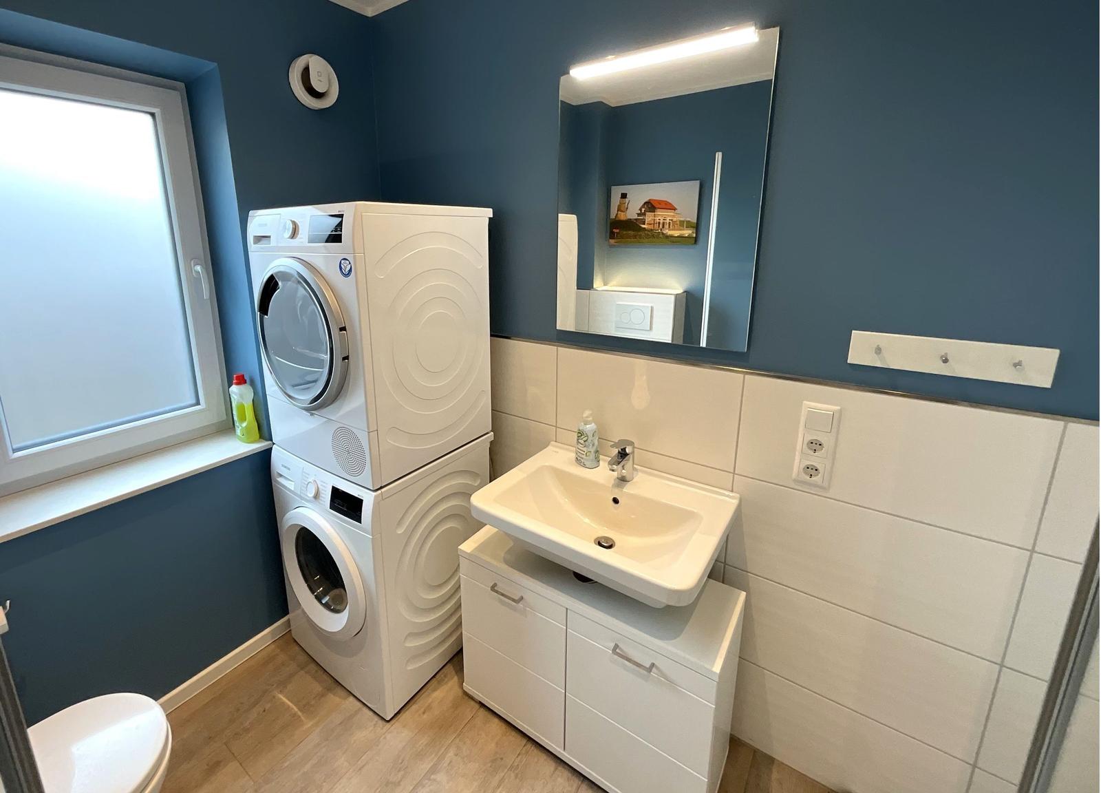Badezimmer mit Waschmaschine, Trockner und Waschbecken