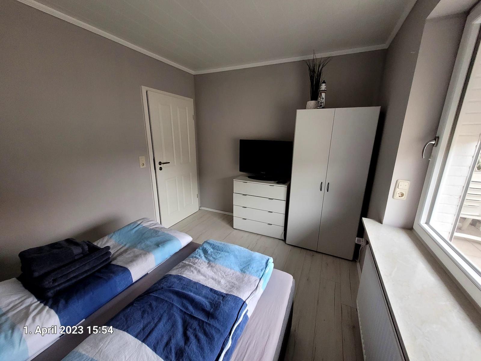 Zimmer mit Doppelbett, Schrank, TV und Fenster mit Blick.