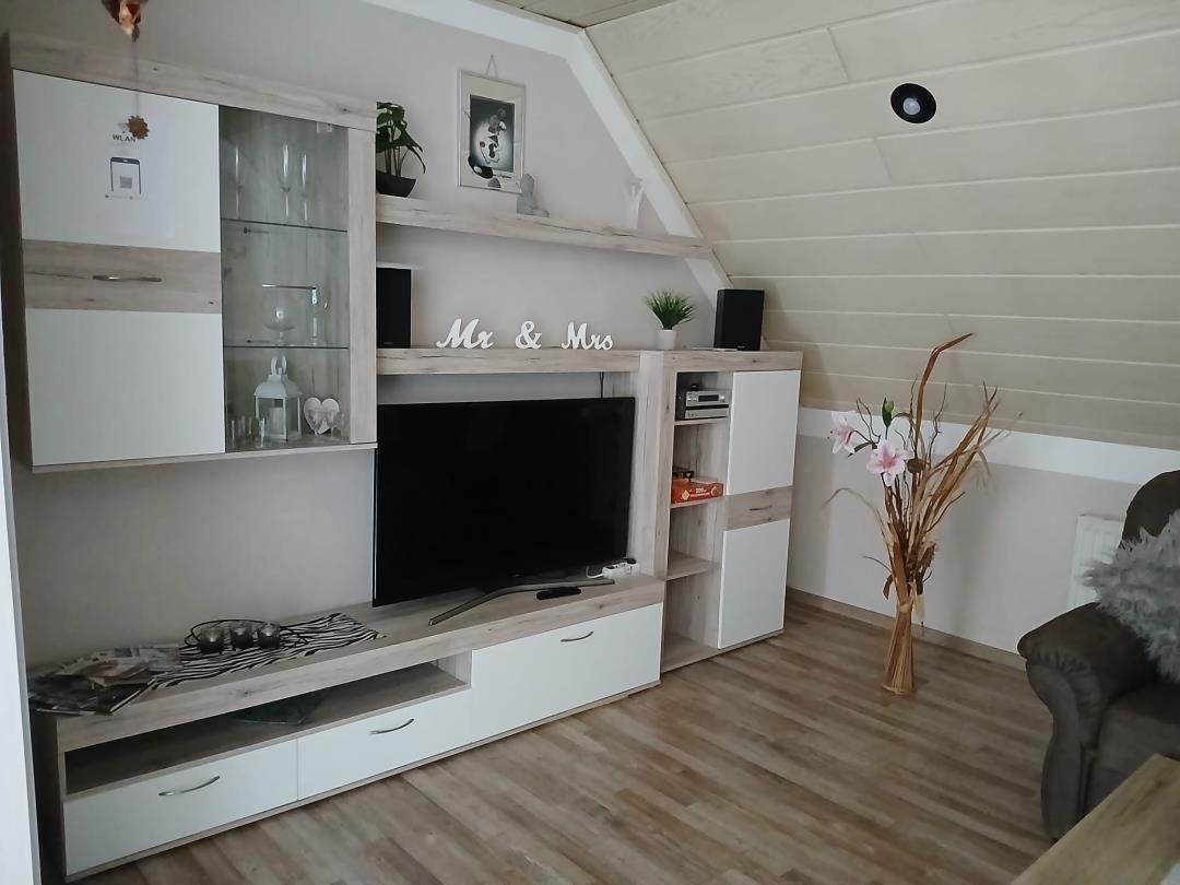 Living room with TV, cabinet, and armchair