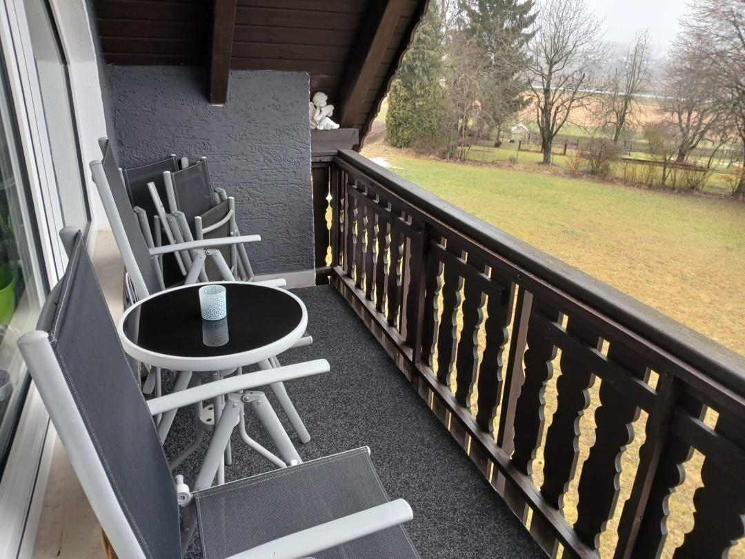 Deck with table and chairs, view of green field