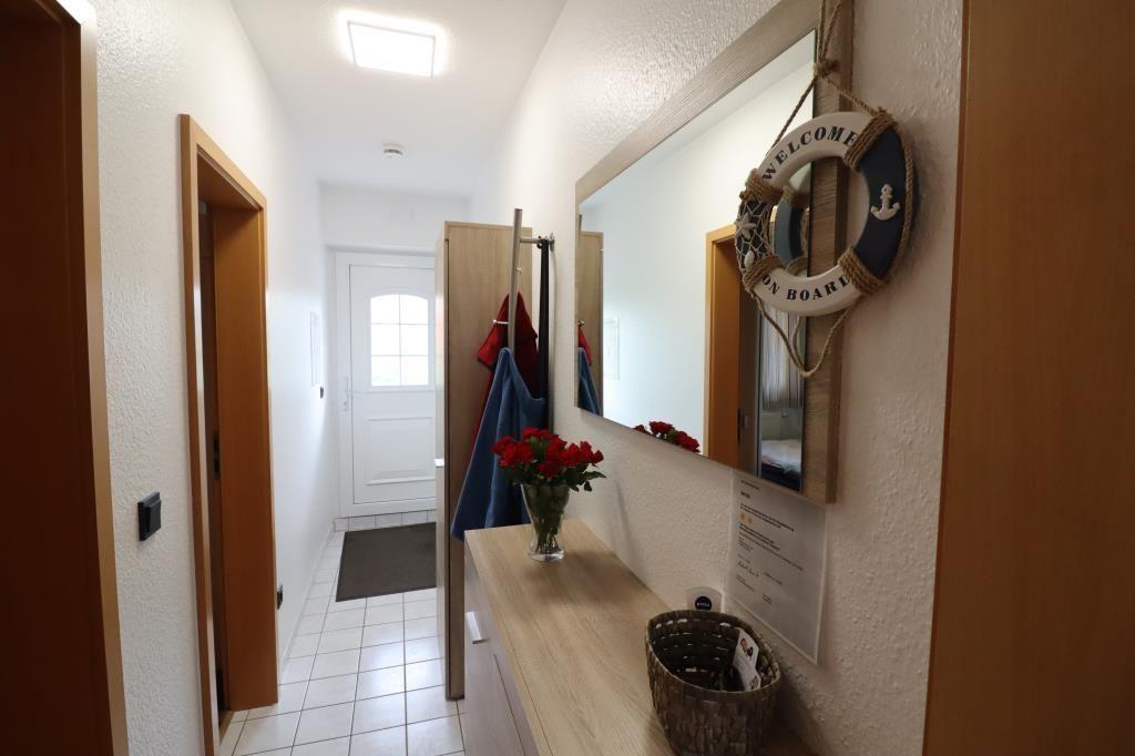Hallway with mirror, welcome ring, and flowers on console