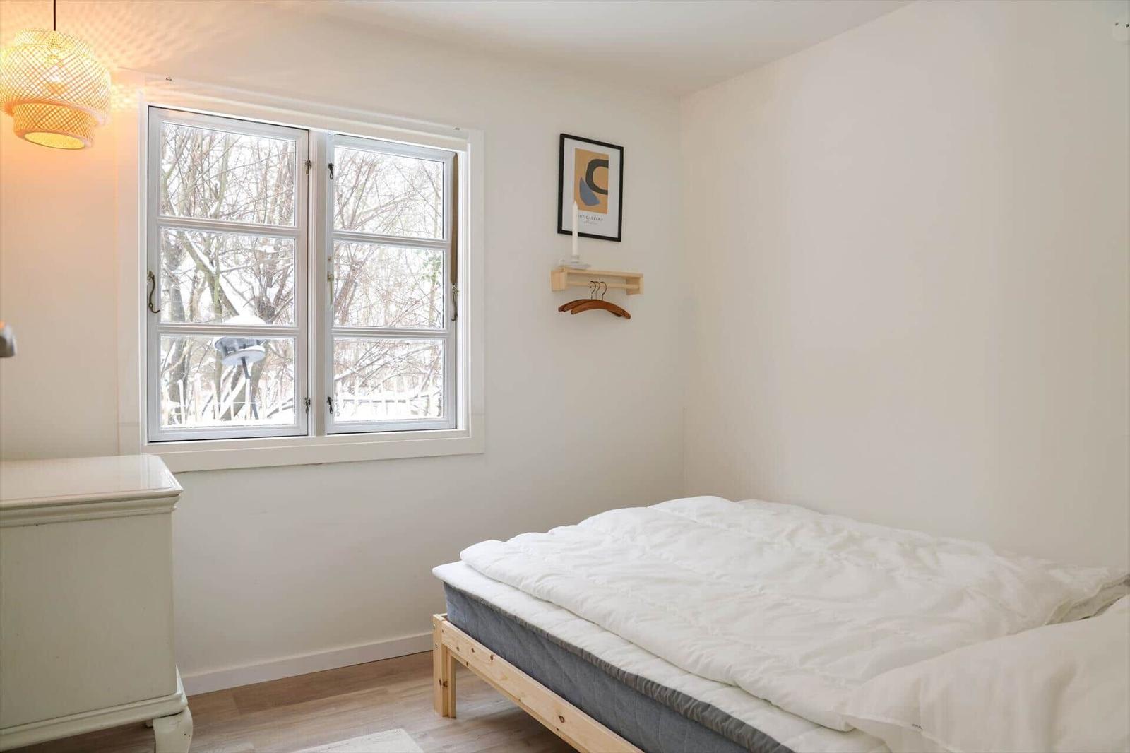 Schlafzimmer mit Bett, Fenster und Schrank.