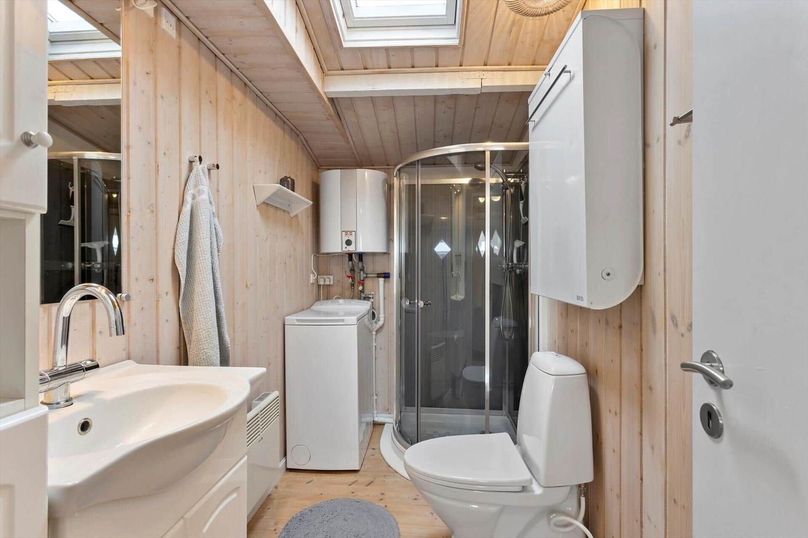 Bathroom with shower, toilet, and washing machine.