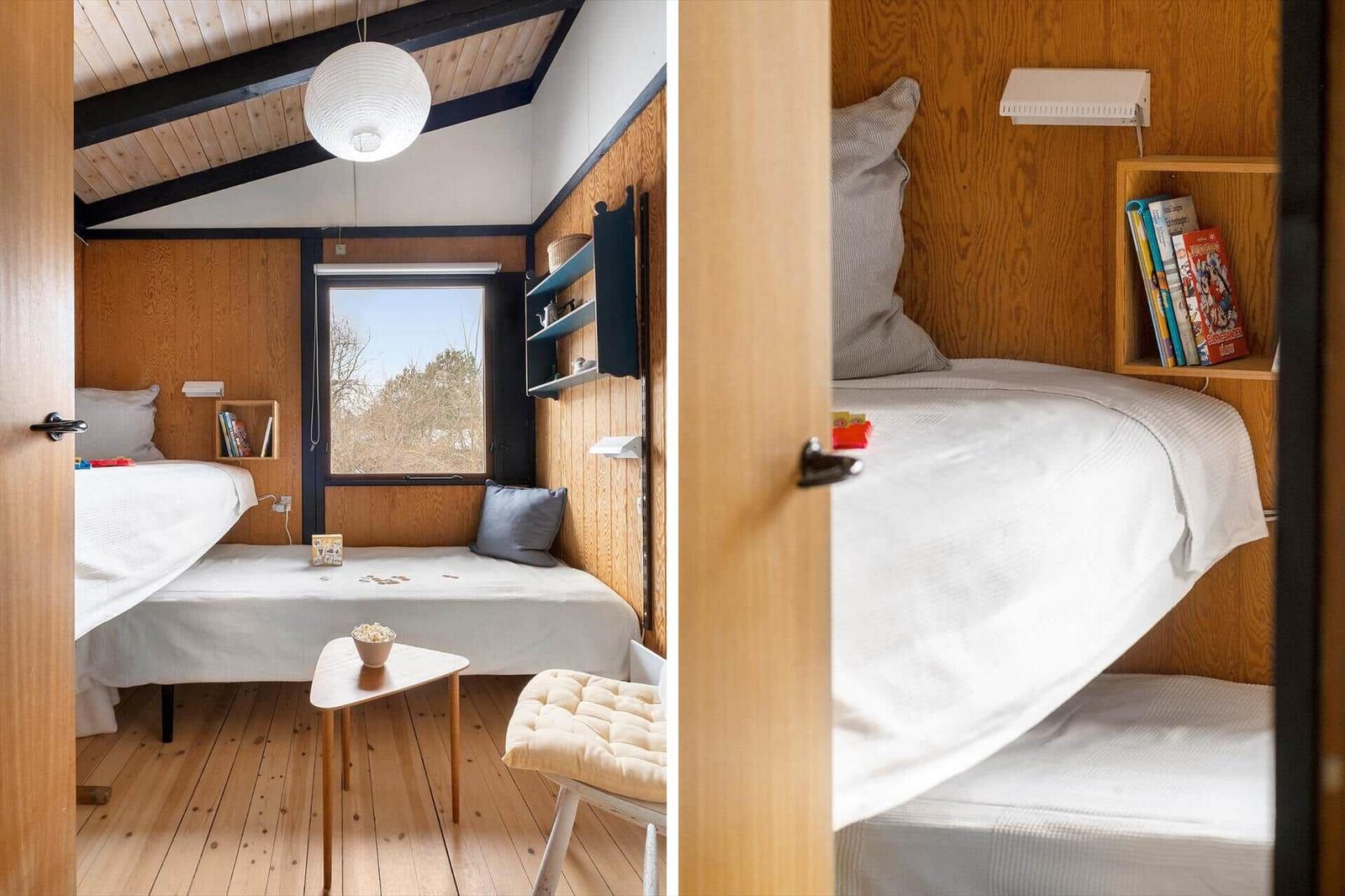 Room with wooden walls, bed, window, and small table.