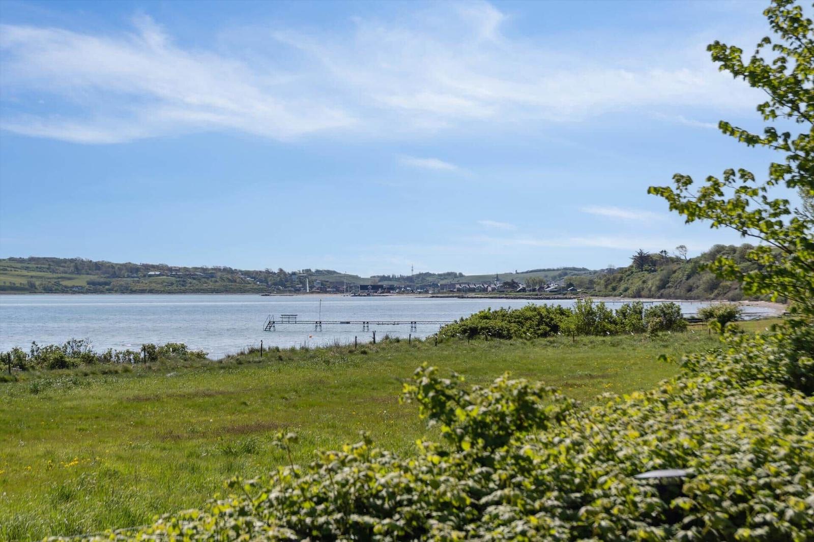 Grünes Feld mit Blick auf Wasser und Ferienort