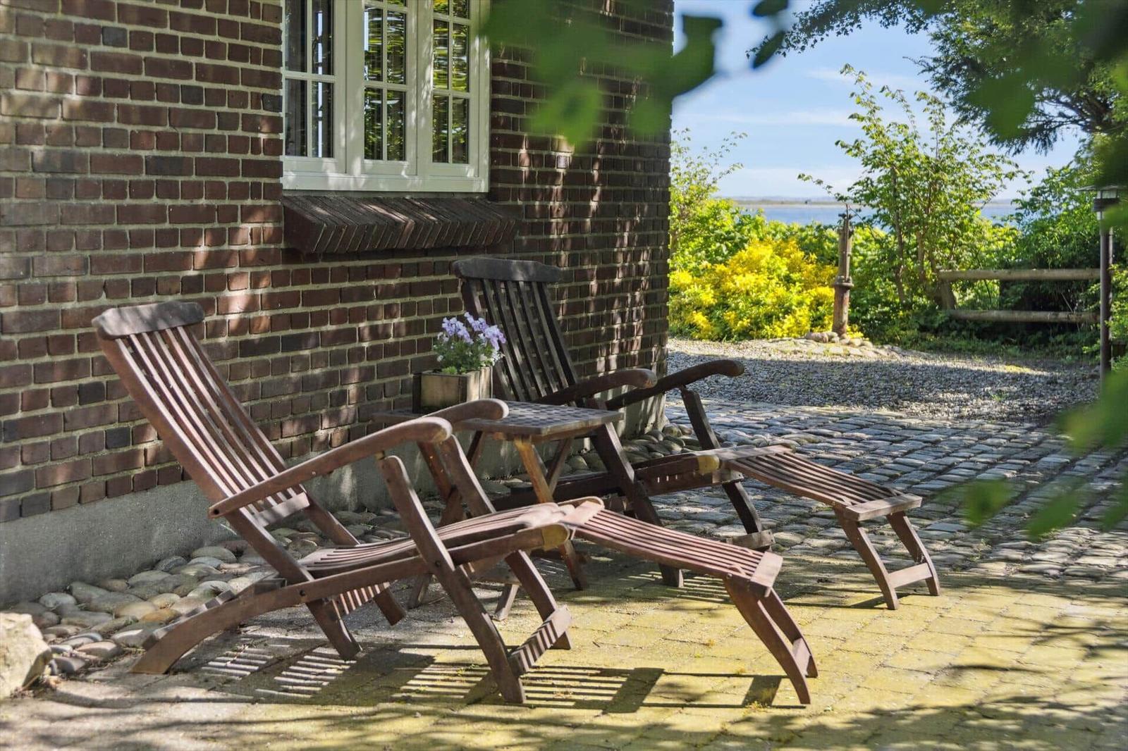 Terrasse mit Holzliegen und Blick auf den See