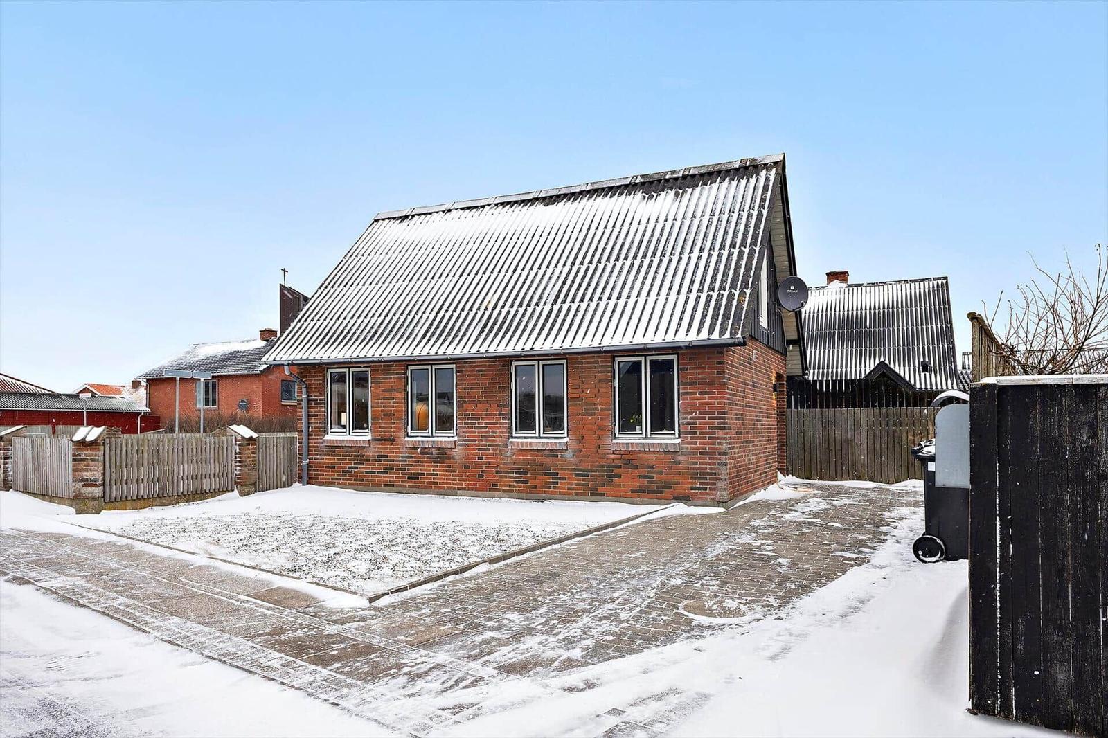 Einfamilienhaus mit Schneebedecktem Dach und Zufahrt