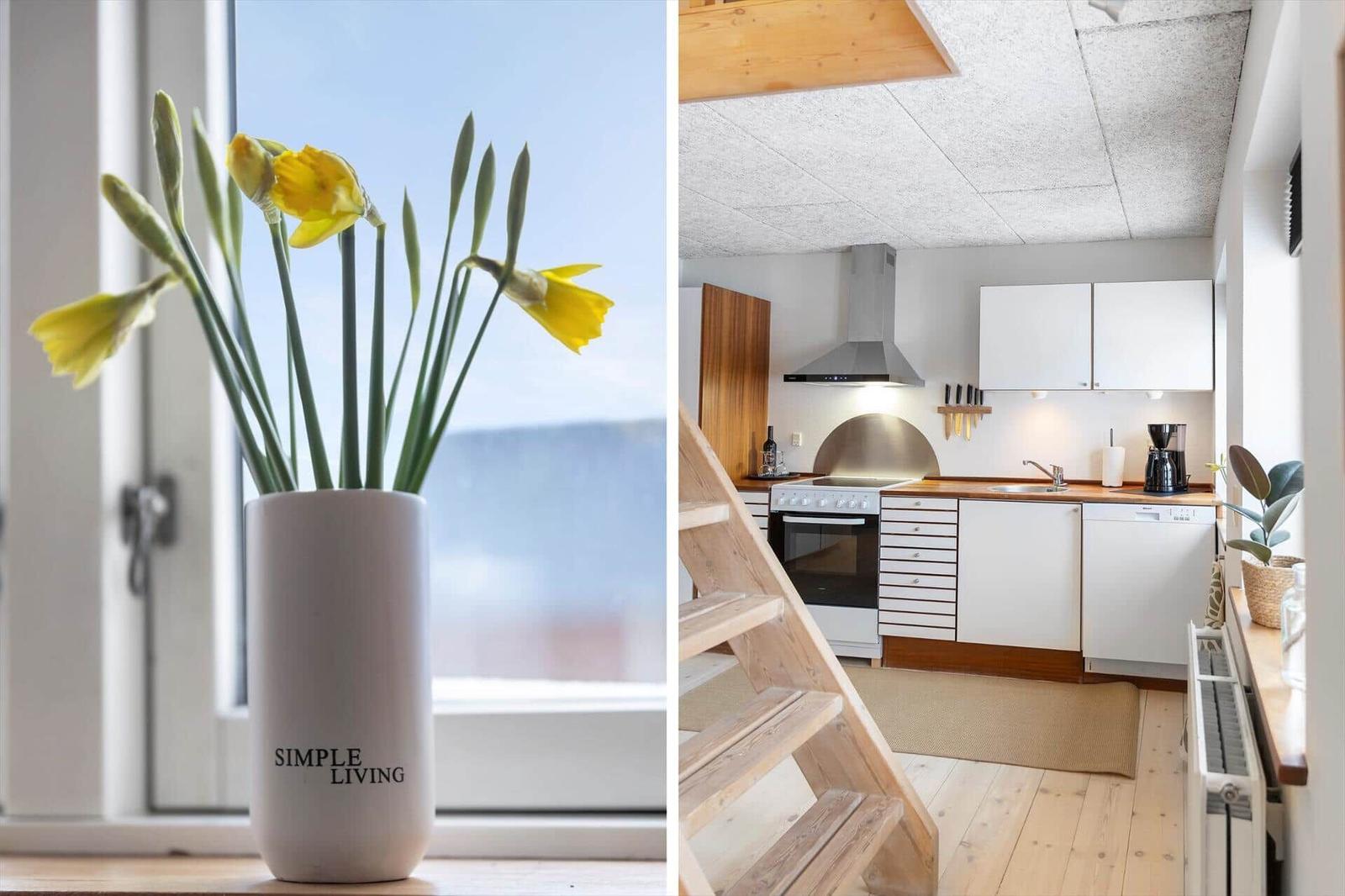 Küche mit Holztreppe und Blumen an Fenster