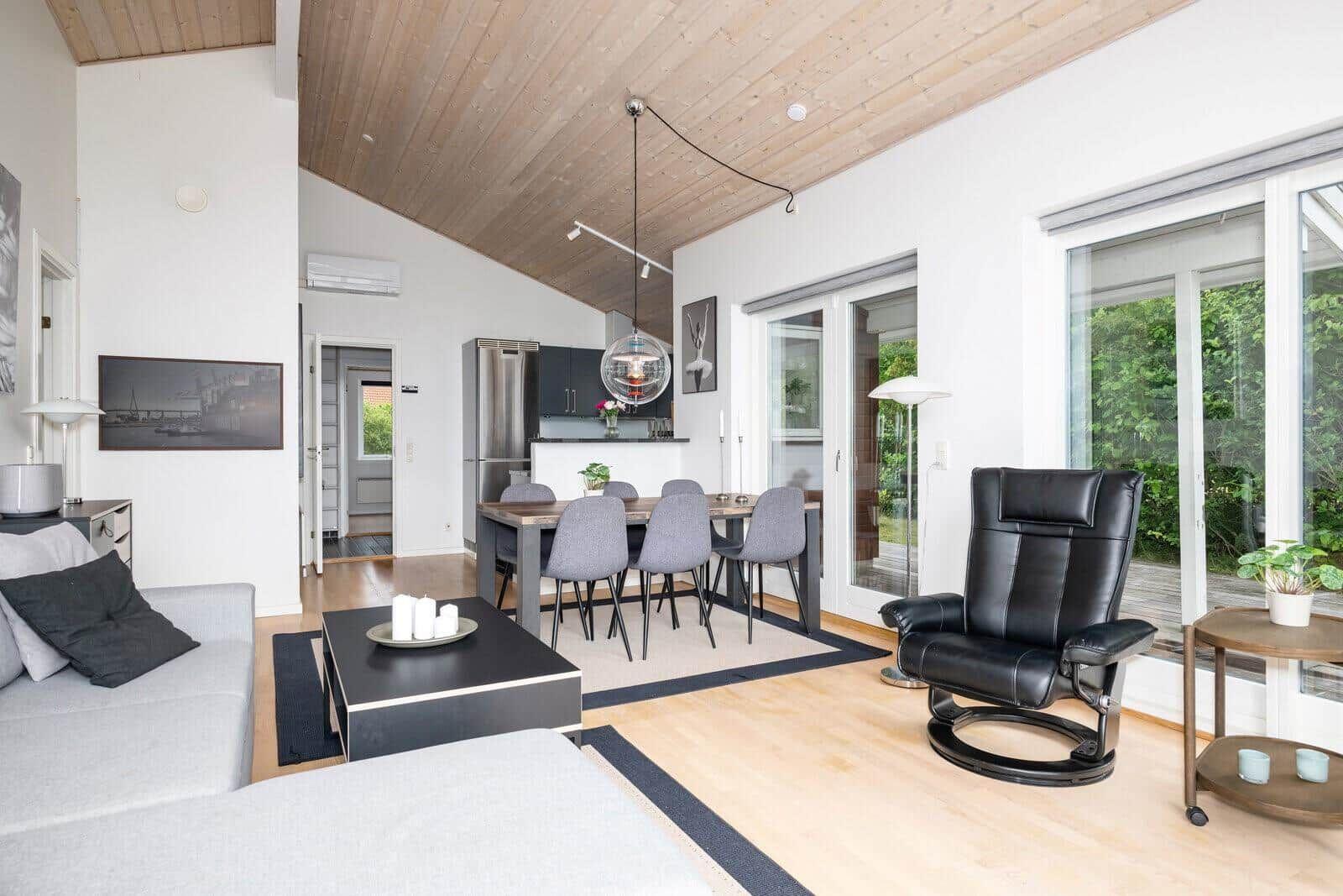 Living and dining area with dining table, sofa, recliner, and kitchen.