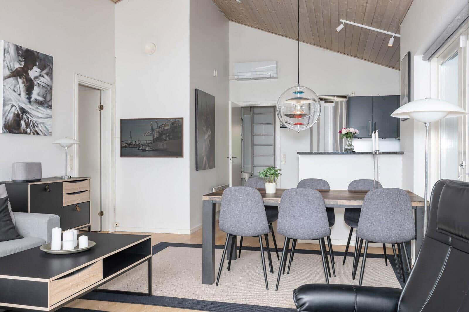 Living and dining area with table, chairs, and modern lighting.