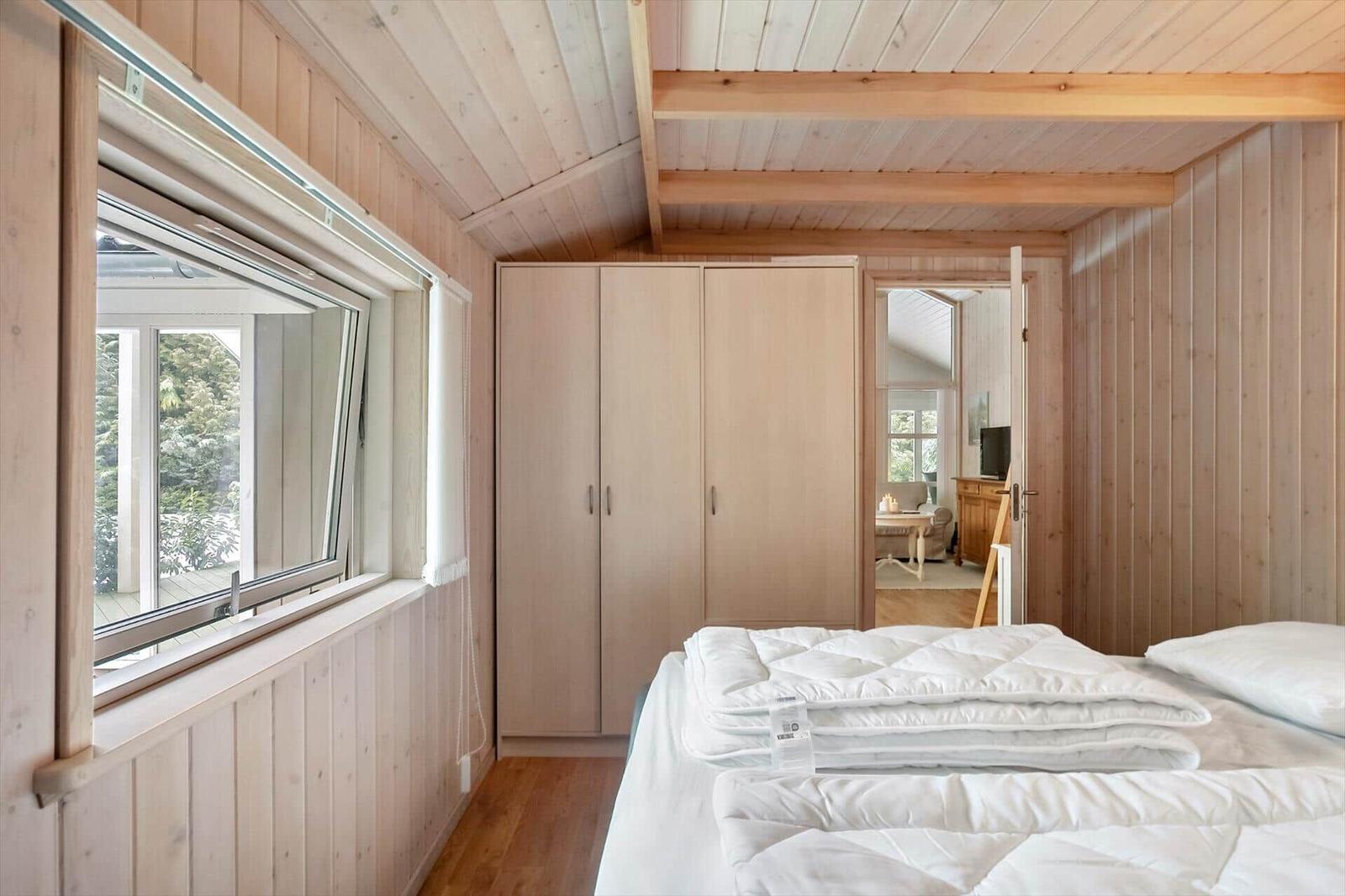 Bedroom with bed, wardrobe, and window with view.