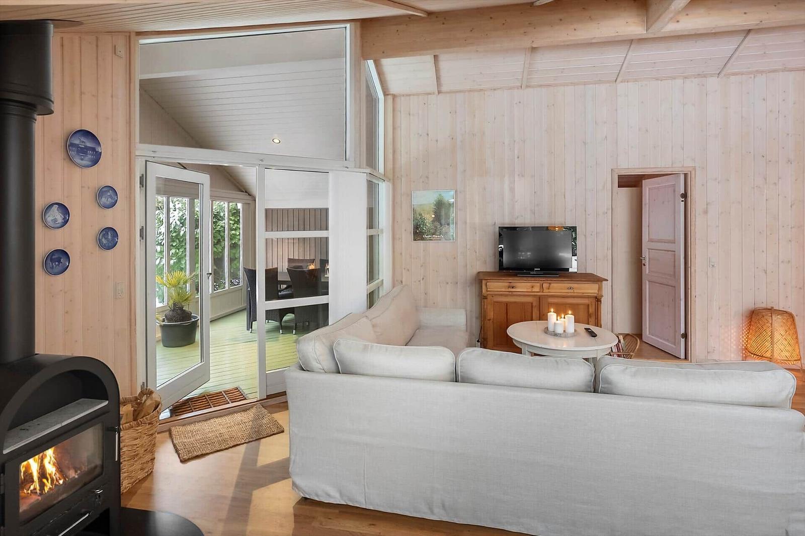Living room with sofa, fireplace, and glass door to terrace