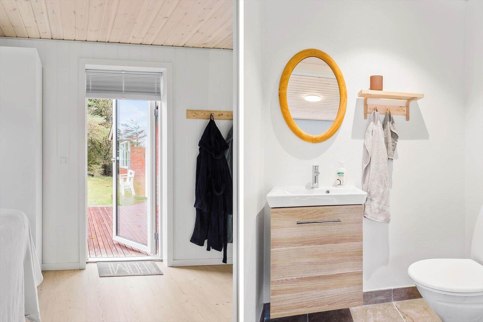 Badezimmer mit Waschbecken, Spiegel und Toilette. Tür führt auf Terrasse.