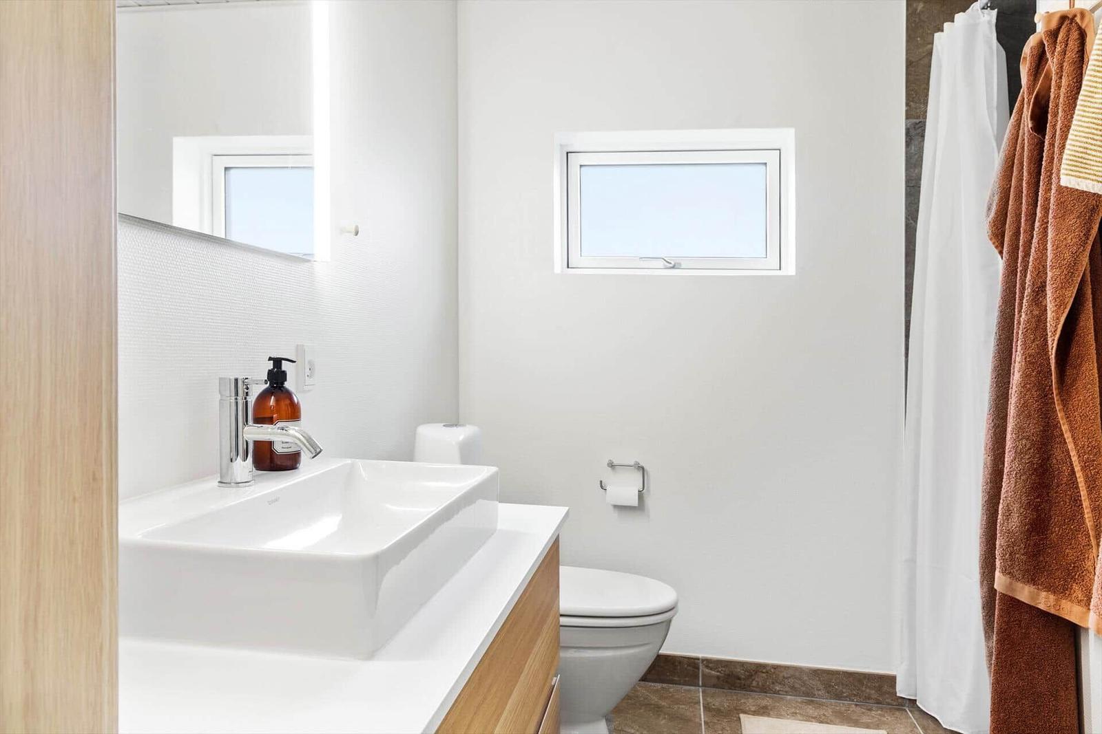 Badezimmer mit Waschbecken, Toilette und Duschvorhang.