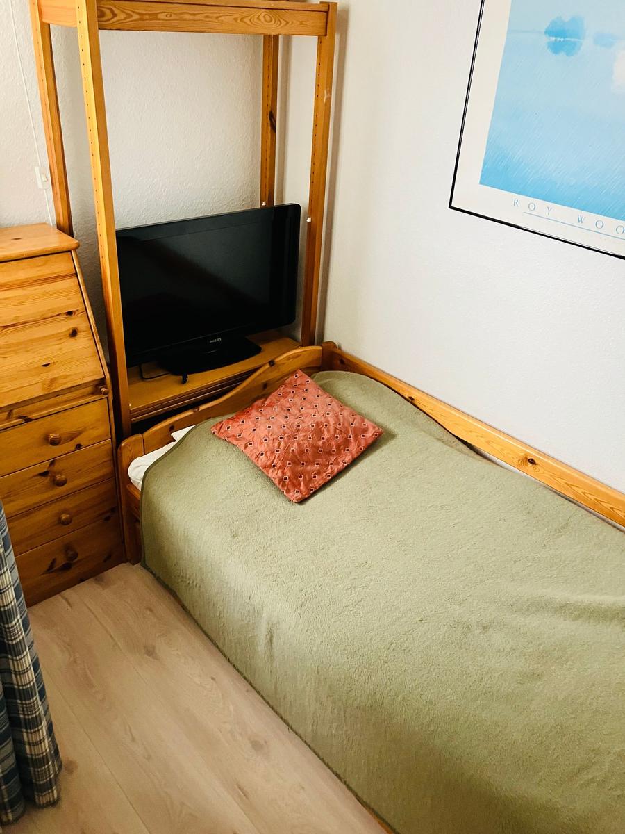 Ein Schlafzimmer mit Bett, Holzmöbel und Fernseher.