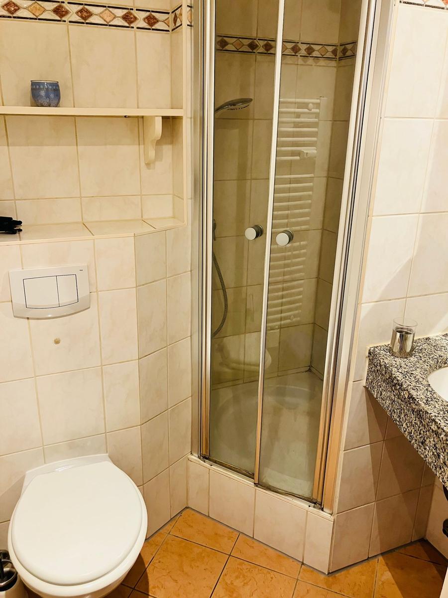 Badezimmer mit Dusche, Toilette und Waschbecken