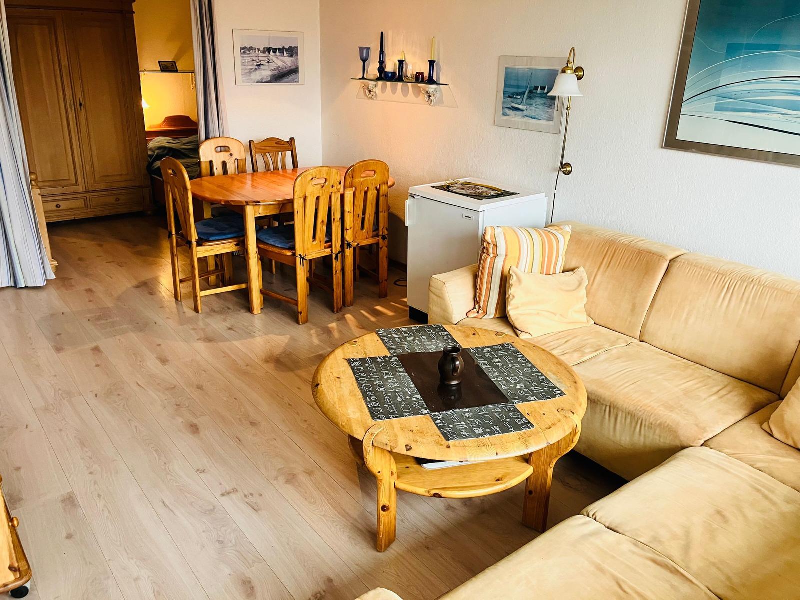 Wohnzimmer mit Sofa, Esstisch und Holzboden
