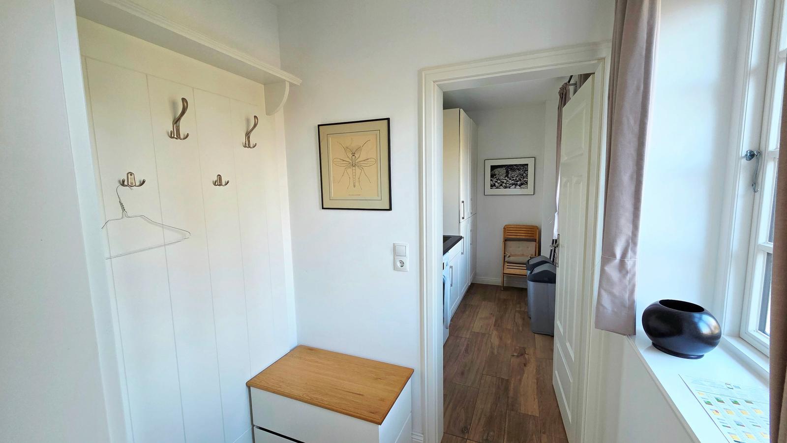 Eingangsbereich mit Garderobe, Bild und Fenster mit Vasen.