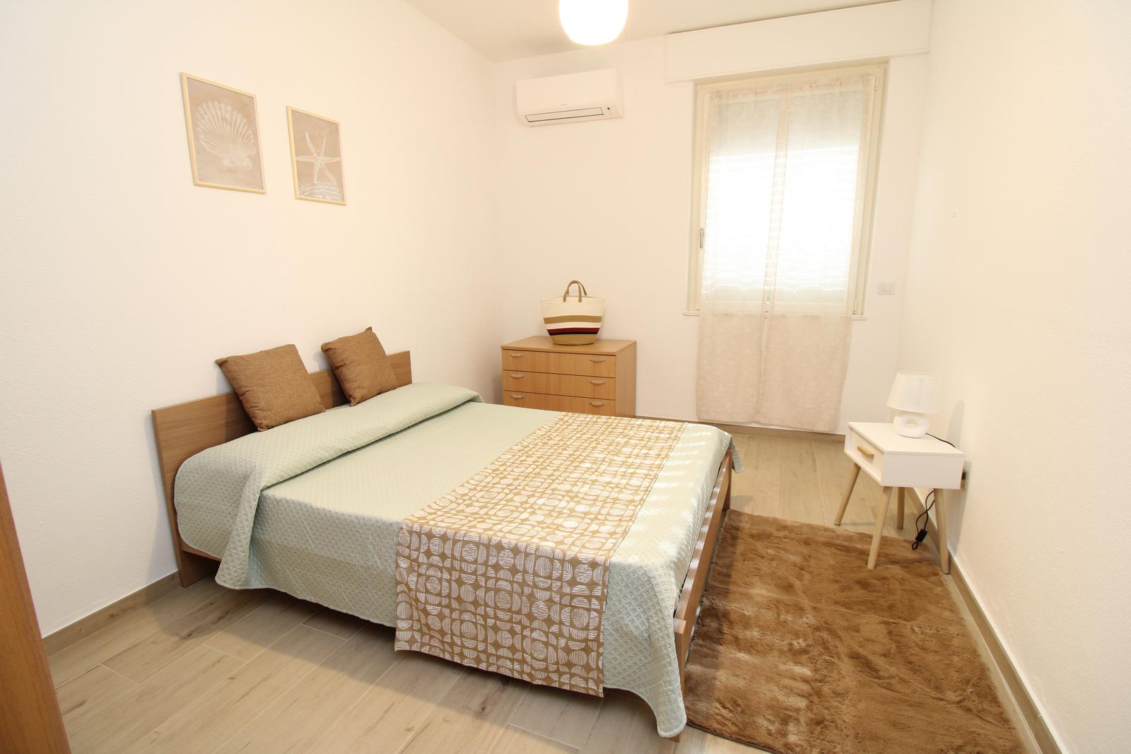 Bedroom with bed, nightstand, dresser, and window