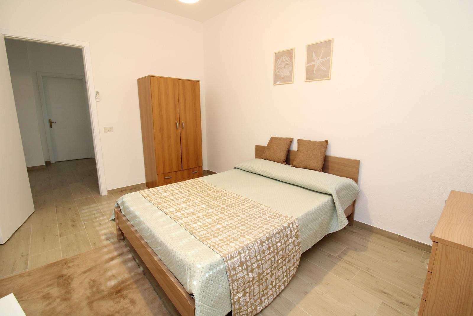 Bedroom with bed, wardrobe, and wall pictures