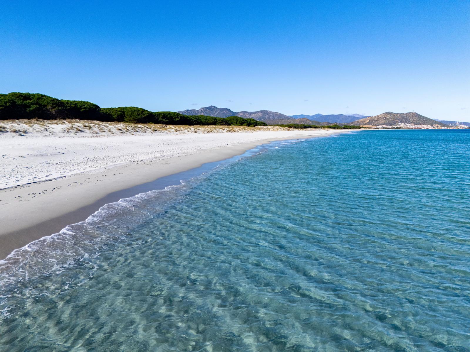 Beach with white sand and turquoise sea under blue sky