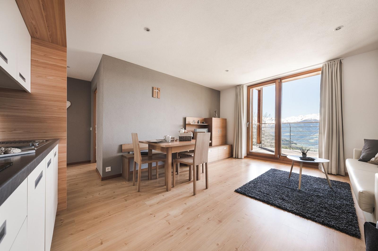 Wohn- und Essbereich mit Blick auf Berge und Holzboden.
