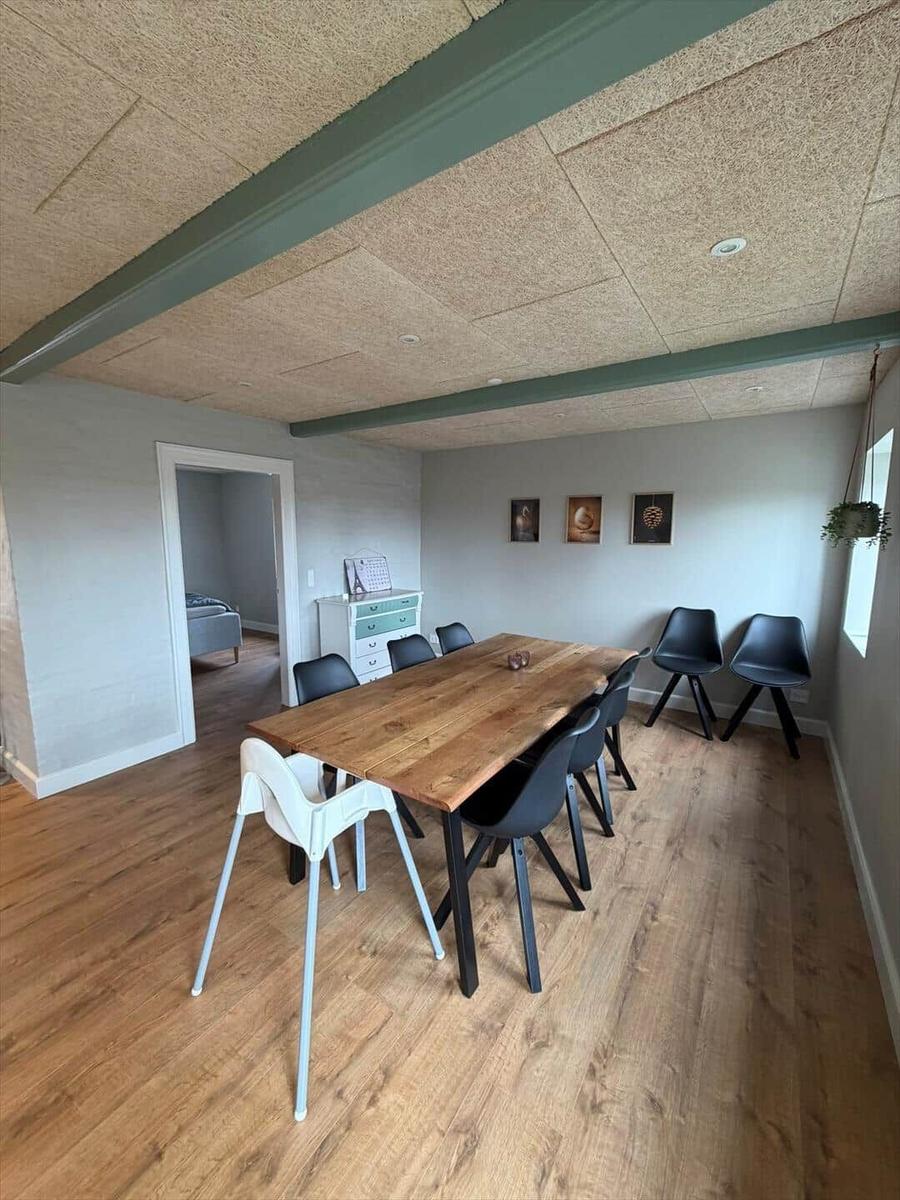 Dining area with wooden table and chairs, hardwood floor, and wall art.