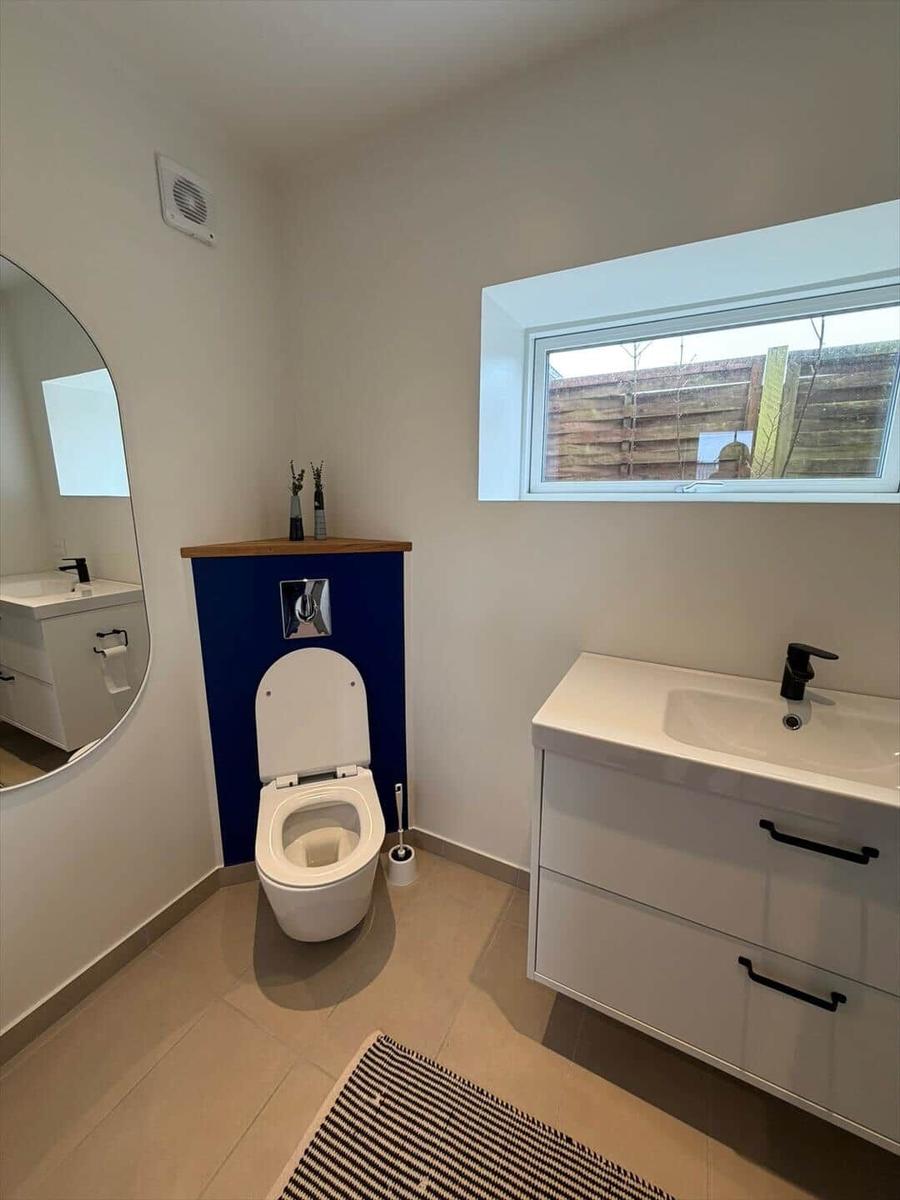 Bathroom with toilet, sink, and window