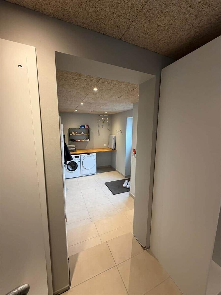 Laundry room with washing machine, dryer, and work surface.