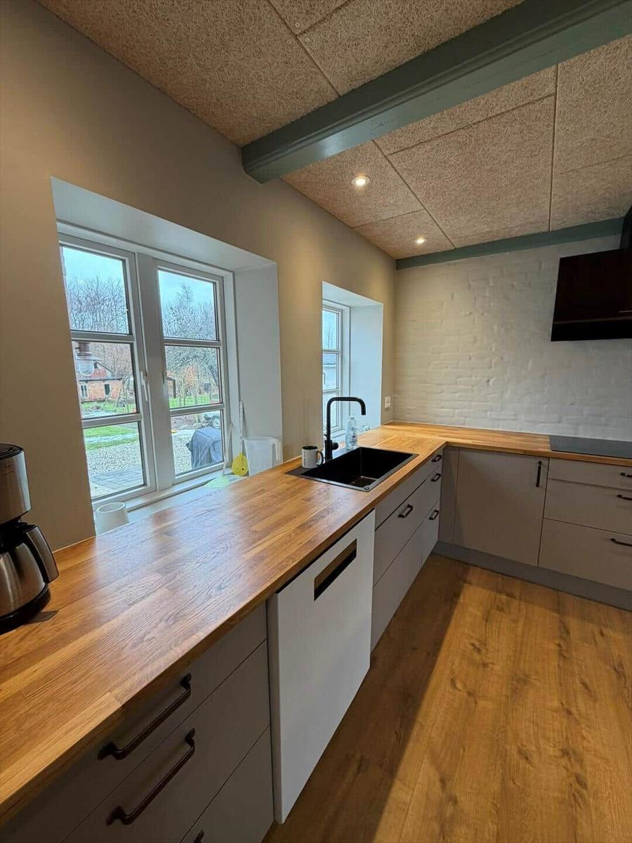 Kitchen with wooden surfaces, windows, and sink